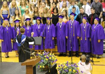 A group of people in purple gowns and hats.