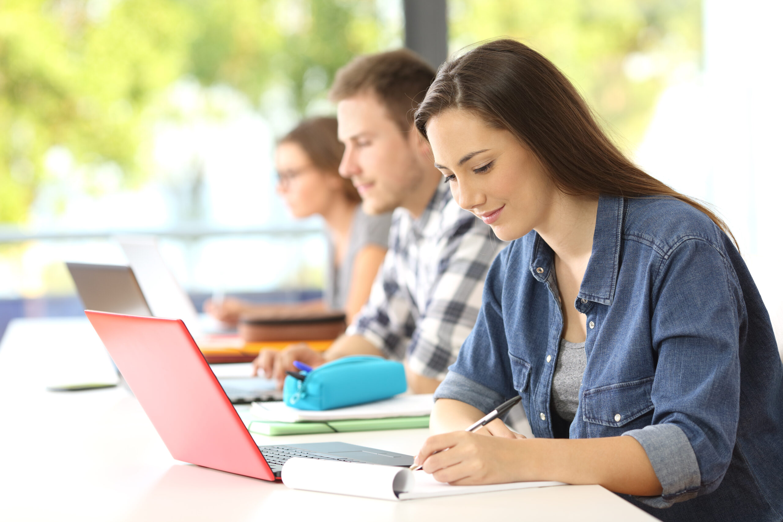 A group of people sitting at tables with laptops.